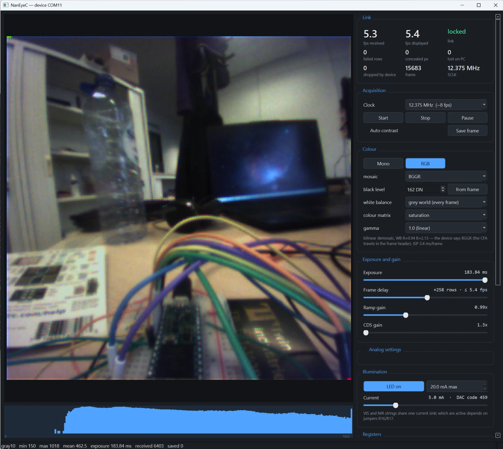 The camera GUI streaming a colour image of a room, with the link statistics, the colour and ISP controls, exposure and illumination panels, and a histogram